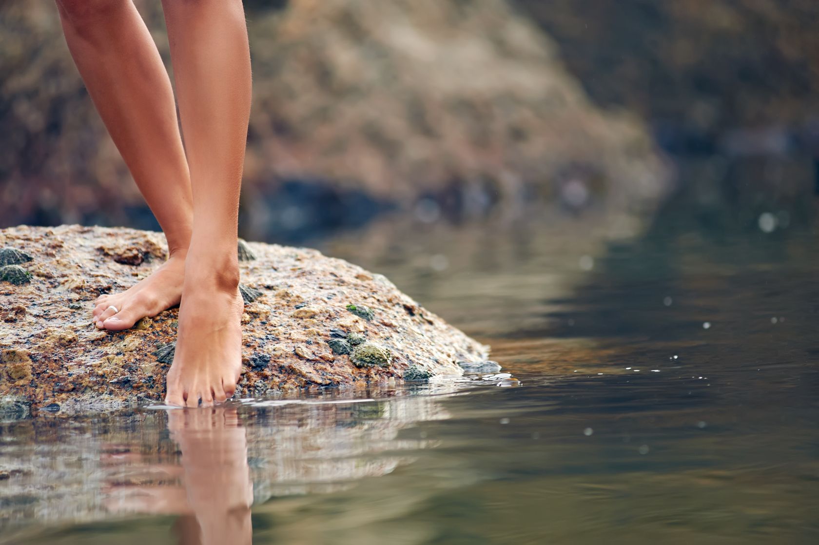 Woman's legs dipping in water